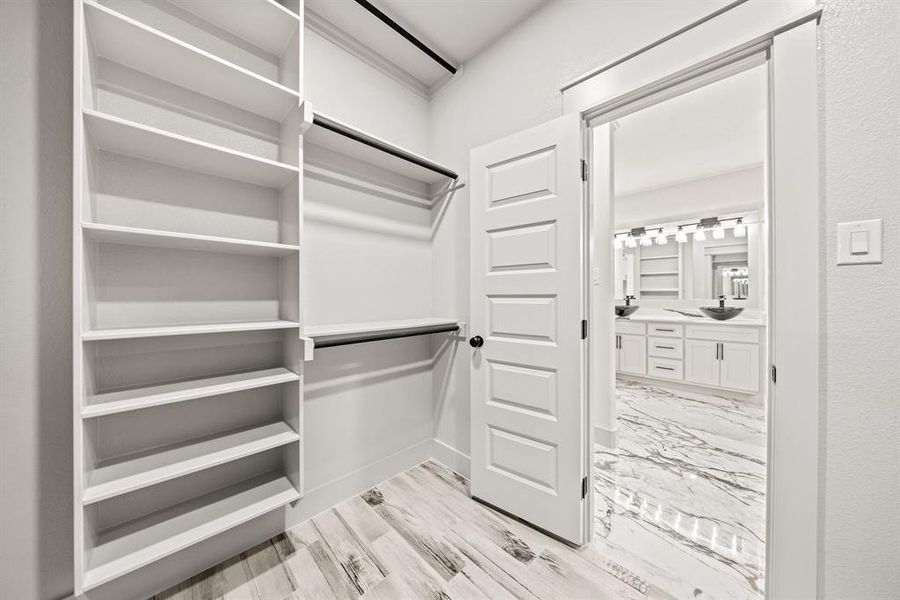 Walk in closet featuring light wood-style floors and a sink Walk in closet featuring light wood-style floors and a sink