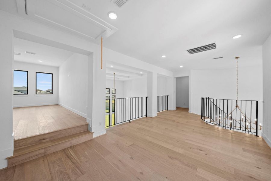 Versatile upstairs living area featuring high ceilings, recessed lighting, and an open layout.