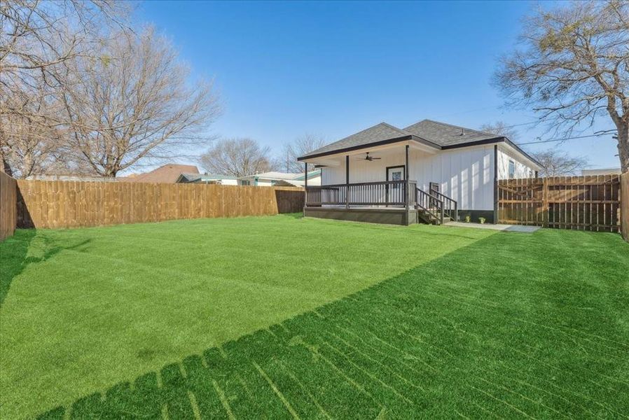 View of yard with ceiling fan and a fenced backyard