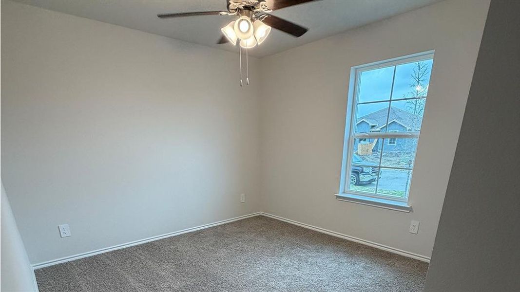 Spare room featuring ceiling fan and carpet floors