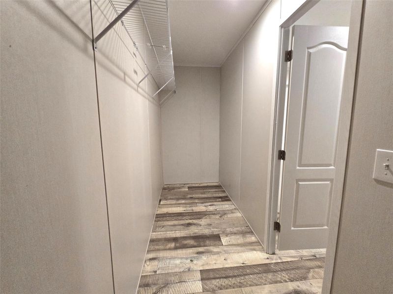 This master closet offers a spacious, well-lit sanctuary with stylish flooring and ample shelving, perfect for organizing your wardrobe in elegance. This master closet offers a spacious, well-lit sanctuary with stylish flooring and ample shelving, perfect for organizing your wardrobe in elegance.
