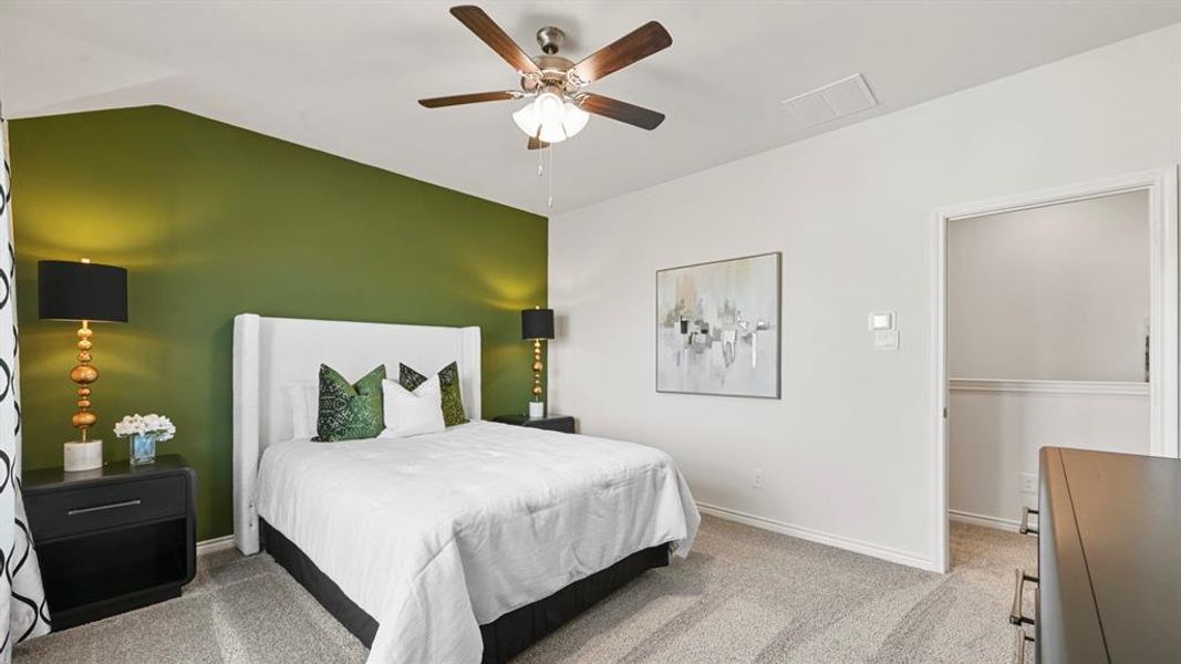 Bedroom with light colored carpet, a ceiling fan, and vaulted ceiling