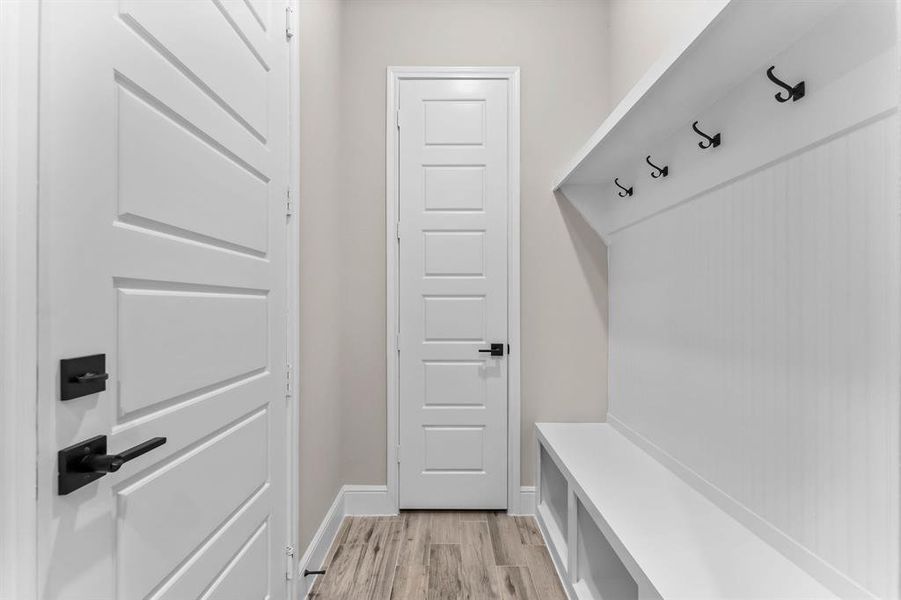 Mud room with custom shelves and coat closet coming in from garage