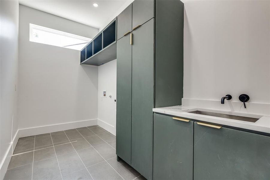 Laundry area with sink, washer hookup, and light tile floors