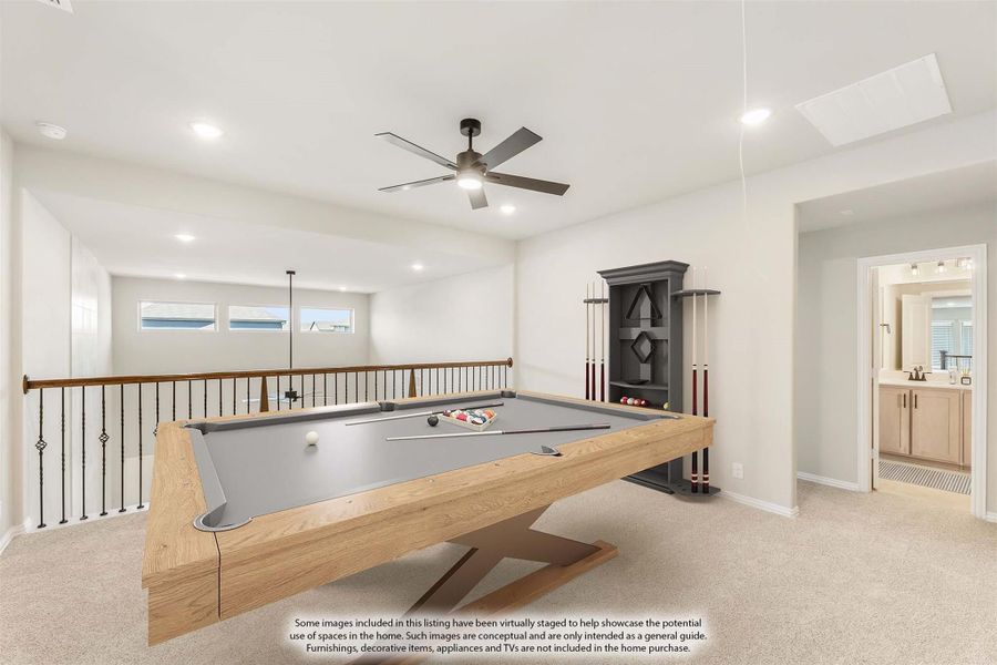 Upstairs game room with pool table, cue rack, ceiling fan, stair railing, and adjoining bathroom on carpet flooring.