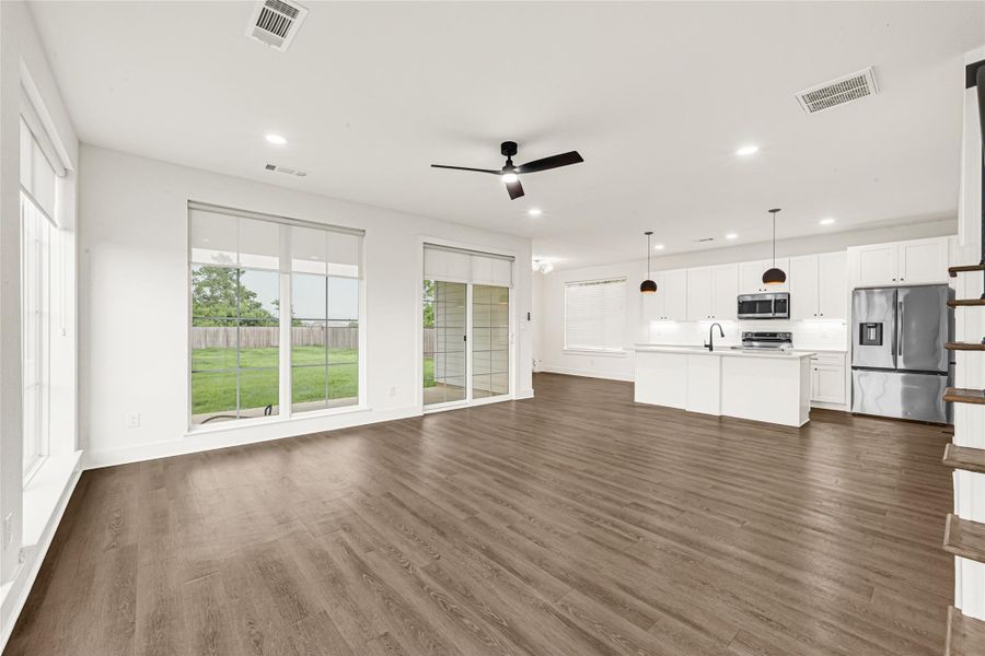 Modern glass doors provide a seamless transition to the covered back patio. Notice the abundance of natural light in the home brought by the large windows found throughout.