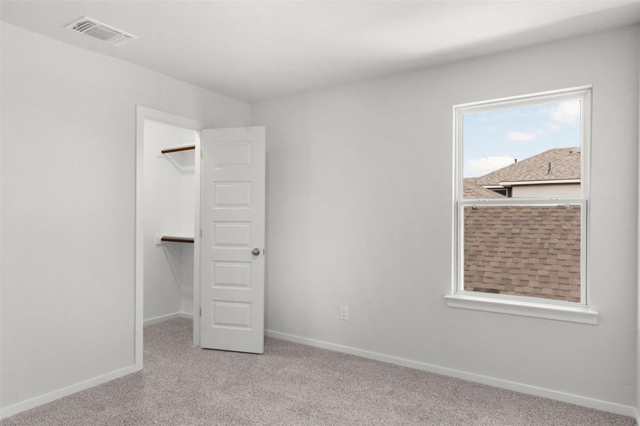 Unfurnished bedroom featuring a spacious closet and light carpet Unfurnished bedroom featuring a spacious closet and light carpet