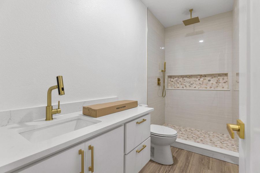 Bathroom with vanity, a tile shower, and light wood finished floors