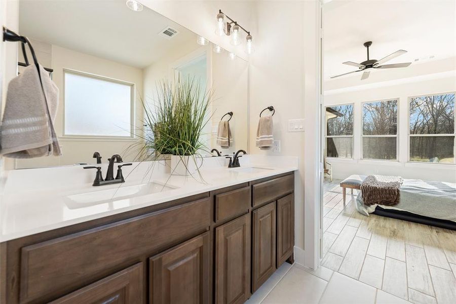 Full bathroom featuring double vanity, ceiling fan, and wood finish floors