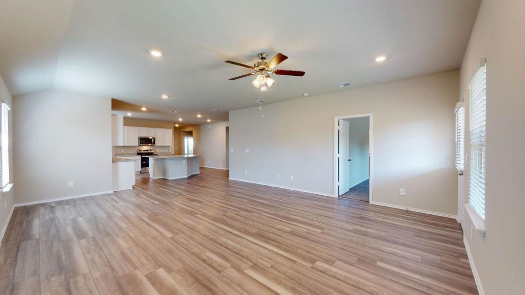 Unfurnished living room with healthy amount of natural light, recessed lighting, ceiling fan, and light wood-type flooring