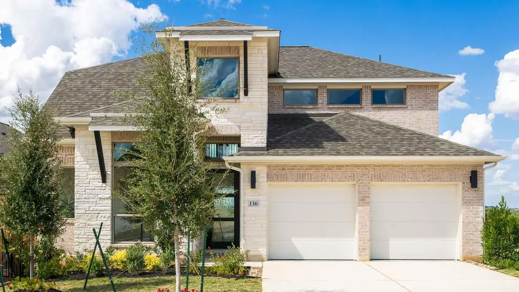 View of front of house with a shingled roof, concrete driveway, a garage, and stone siding View of front of house with a shingled roof, concrete driveway, a garage, and stone siding