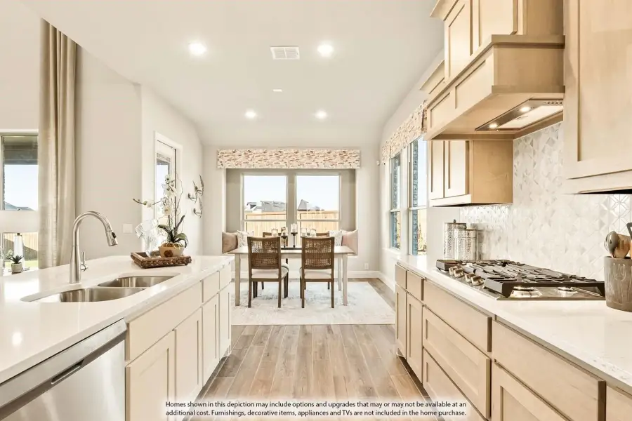 Kitchen with white countertops, light wood cabinets, gas cooktop, and dining area visible in background