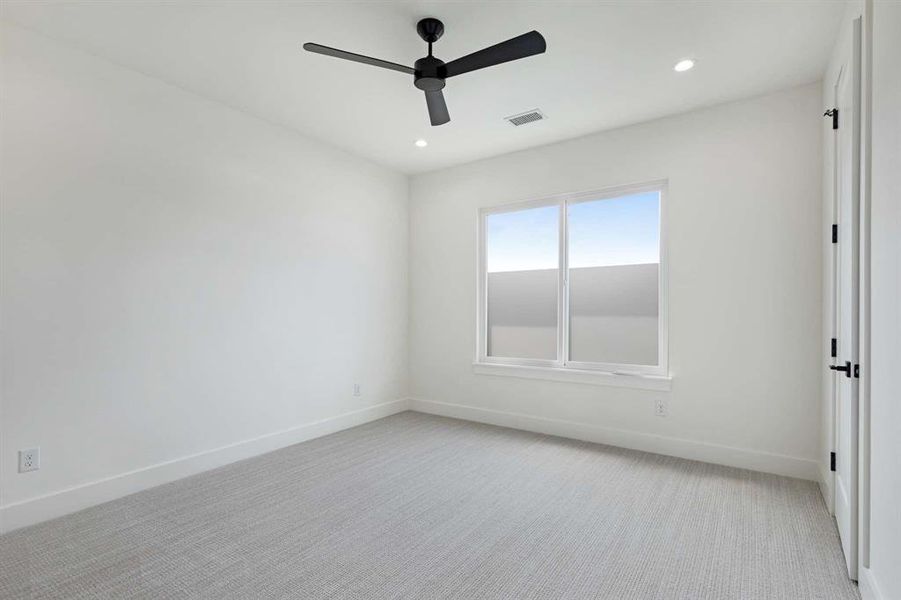 Carpeted empty room featuring ceiling fan