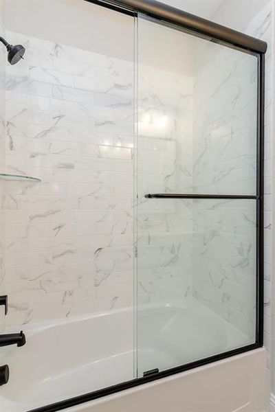 Bathroom with shower / bath combination with glass door