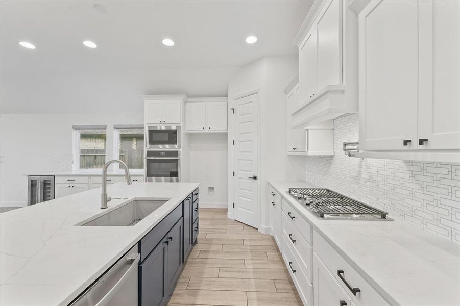 Kitchen includes double ovens, pot filler and oversized cook top with vent hood.