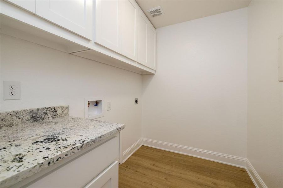 Clothes washing area with hookup for an electric dryer, cabinets, and hookup for a washing machine