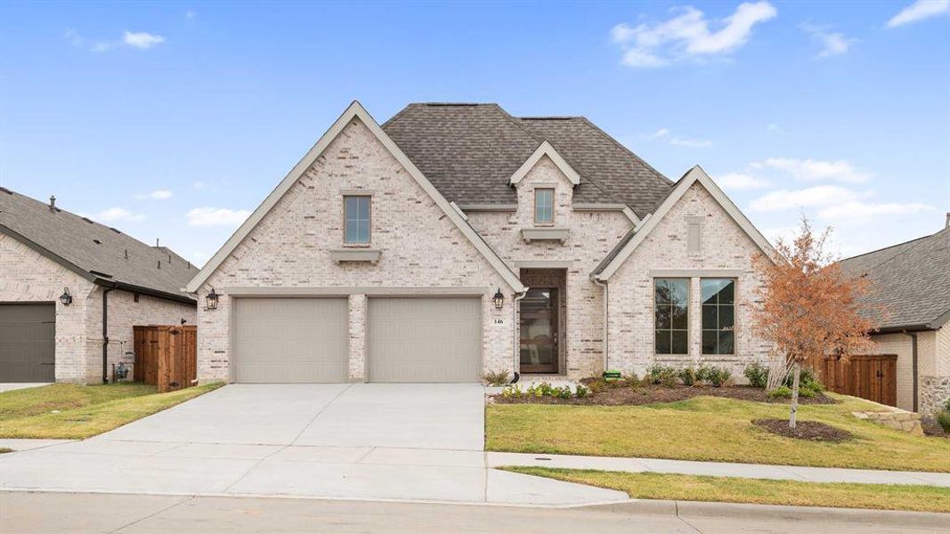 View of front of house featuring a front lawn and a garage