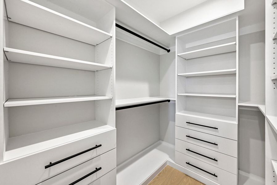 3rd Floor Custom Walk-in Closet in Primary Bathroom. (This is Unit #2 - each Unit has the same layout, however a few differing details such as light fixtures, custom cabinet/backsplash/tile colors)