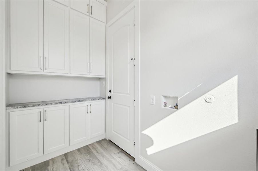 Laundry room with washer / dryer connections and built-in storage, connected to the garage and entryway.