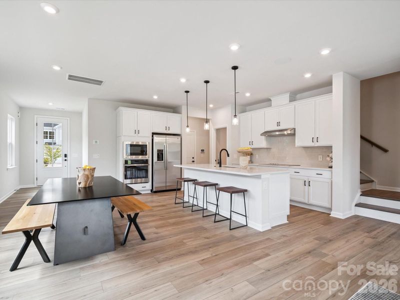 Gourmet kitchen with white cabinets and white quartz countertops
