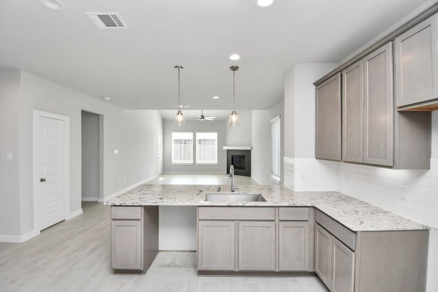 The extended counter area adds both practicality and style, making meal preparation a breeze. Every detail is thoughtfully designed to enhance the kitchen's functionality and aesthetic appeal. Sample photo of completed home with similar floor plan. Actual colors and selections may vary.