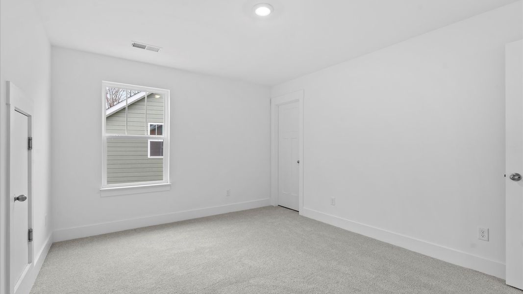 Superior comfort in this light-filled bedroom with plush carpeting and a thoughtfully placed large window at Pleasant Falls