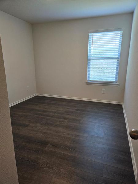 Empty room featuring dark hardwood / wood-style floors