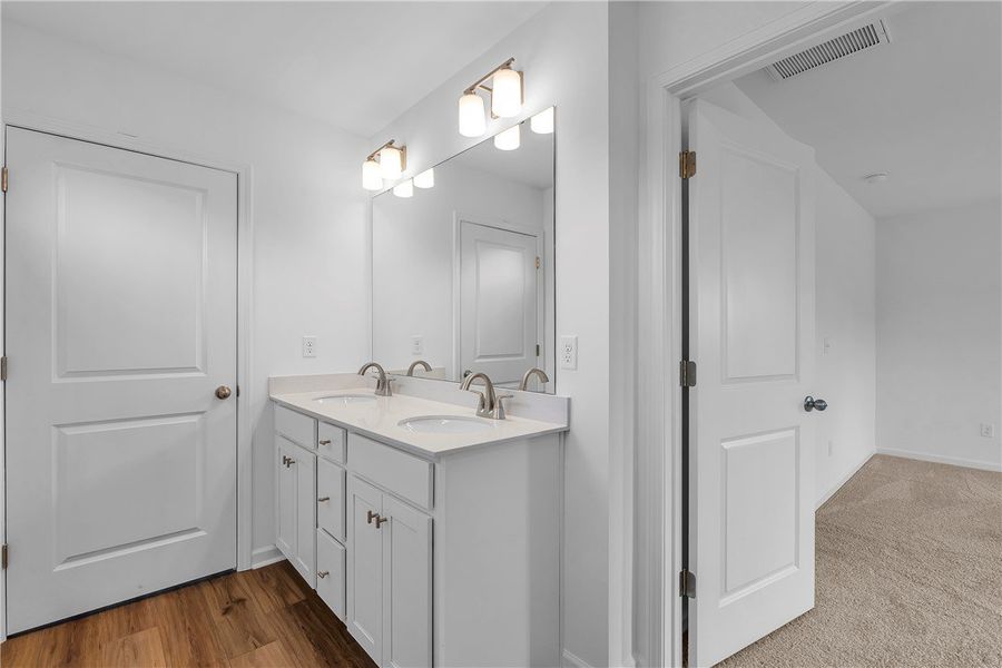This spacious bathroom offers dual vanities, large