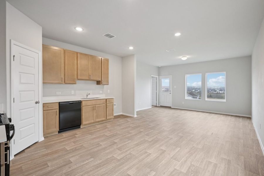 Image of a living and dining room area with windows, grey walls and vinyl flooring