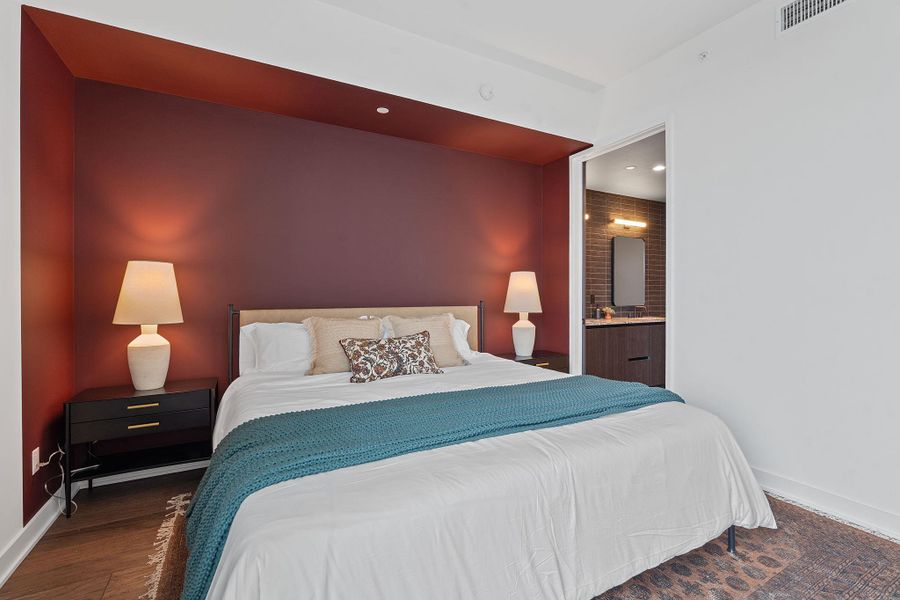 Representative Photo. Primary Bedroom with wood flooring, large window, ceiling fan, and window treatments included