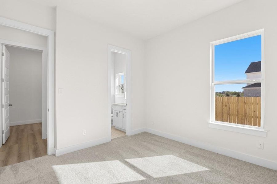 Unfurnished bedroom with light carpet and ensuite bathroom Unfurnished bedroom with light carpet and ensuite bathroom