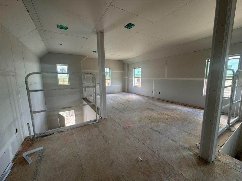 Unfurnished room with plenty of natural light and vaulted ceiling