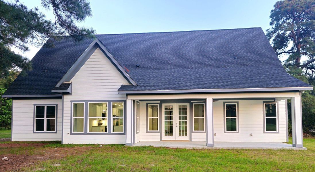 Modern exterior, gabled roof, spacious covered patio, and large windows.