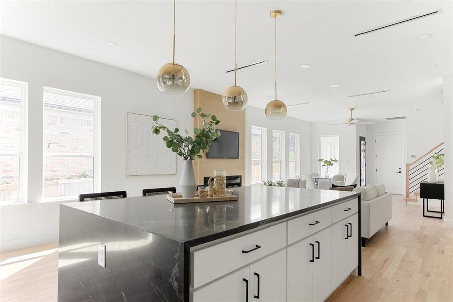 Kitchen featuring a center island, a wealth of natural light, white cabinets, and light hardwood / wood-style flooring