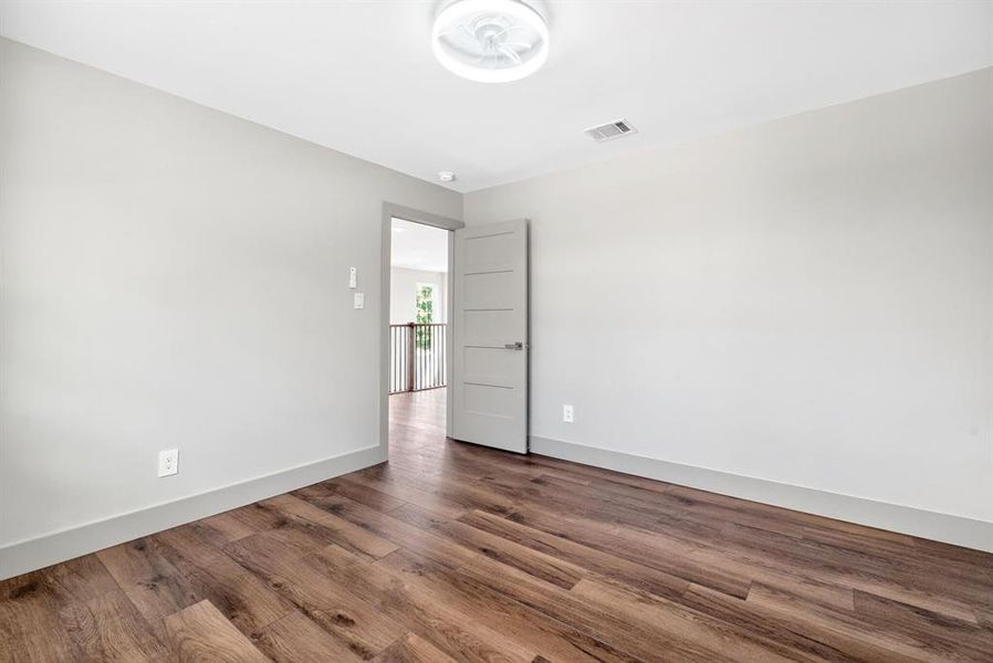 Unfurnished room with dark wood-style flooring and baseboards Unfurnished room with dark wood-style flooring and baseboards