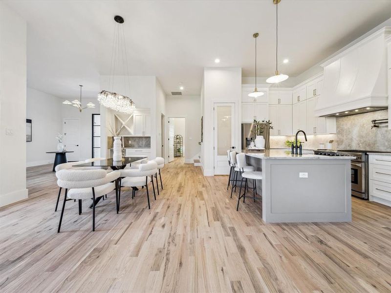 Kitchen featuring white cabinets, pendant lighting, and high end stainless steel range oven