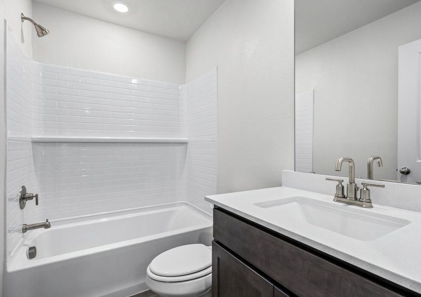 The secondary bathroom has a sprawling vanity and shower-tub combo.