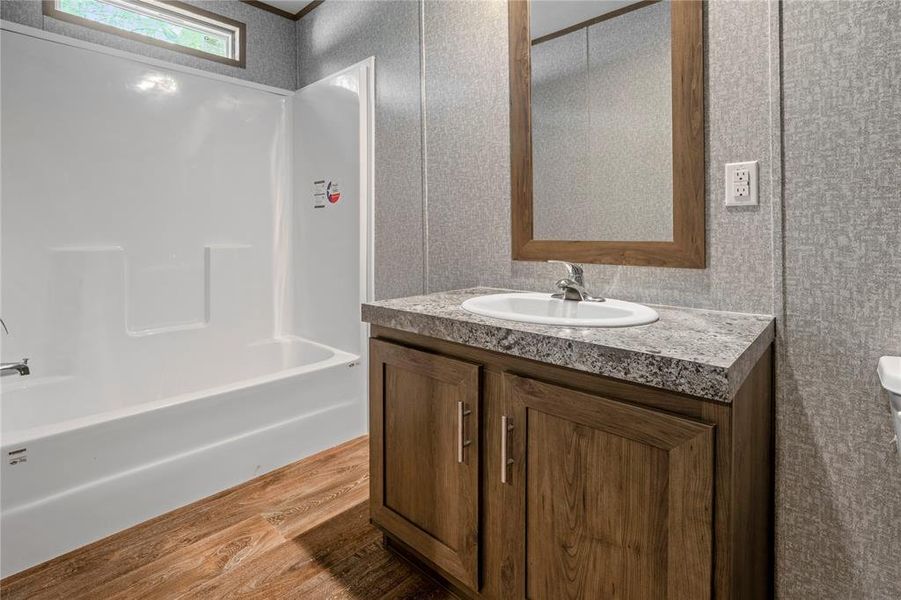 Full bath with wood finished floors, vanity, and shower / bathtub combination