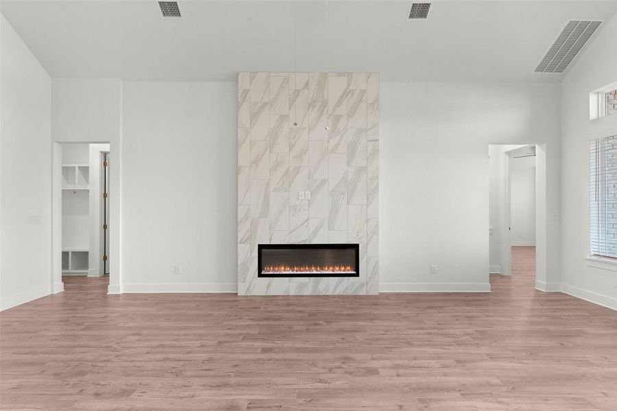 Unfurnished living room featuring light wood finished floors and a fireplace