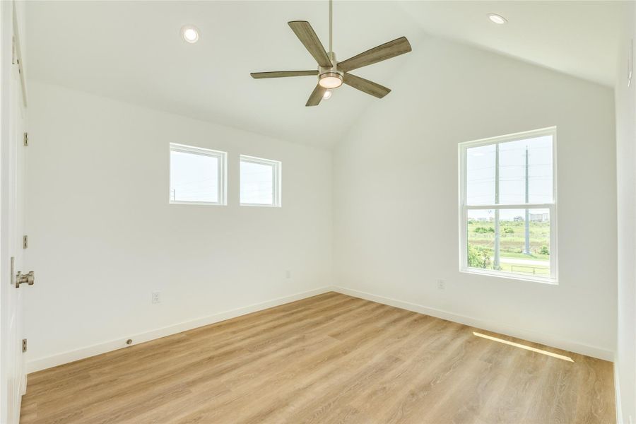 Bedroom located on second floor with vaulted ceiling.
