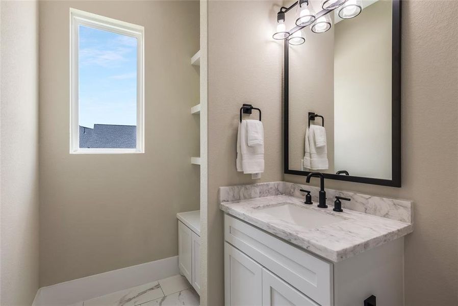 Bathroom #3 with a sleek white vanity, marble countertop, and black fixtures. Built ins to the side for extra storage Bathroom #3 with a sleek white vanity, marble countertop, and black fixtures. Built ins to the side for extra storage