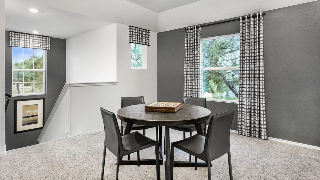 Dining space with light carpet and a textured wall