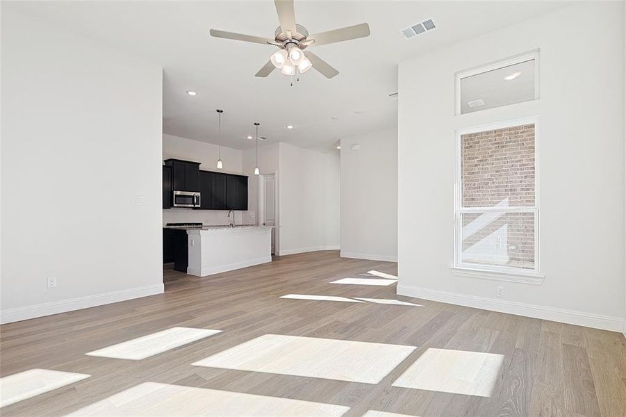 Unfurnished living room with hardwood / wood-style floors and ceiling fan