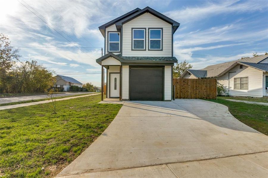 View of front facade with a garage and a front lawn