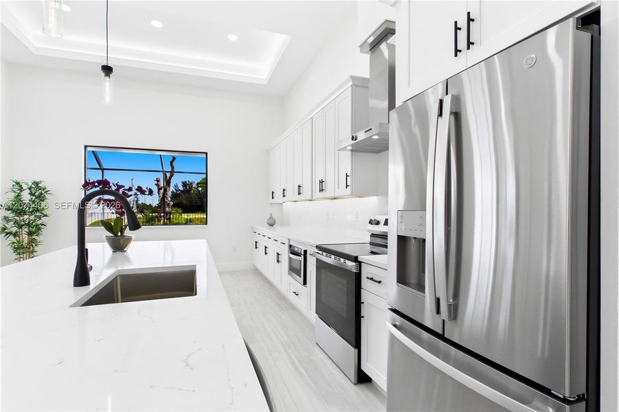 CHEF’S KITCHEN showcases expansive QUARTZ SURFACES, floor-to-ceiling WHITE SHAKER CABINETRY, matte-black fixtures & stainless-steel appliances beneath a dramatic LED-LIT TRAY CEILING. CHEF’S KITCHEN showcases expansive QUARTZ SURFACES, floor-to-ceiling WHITE SHAKER CABINETRY, matte-black fixtures & stainless-steel appliances beneath a dramatic LED-LIT TRAY CEILING.