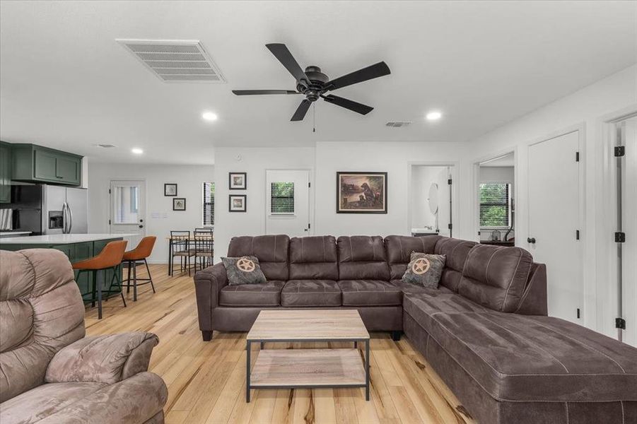 Open-concept living space featuring wood-finish flooring, recessed lighting, and a ceiling fan