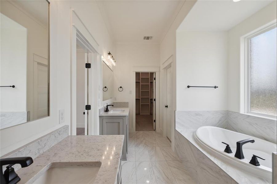 Bathroom with tiled tub and vanity