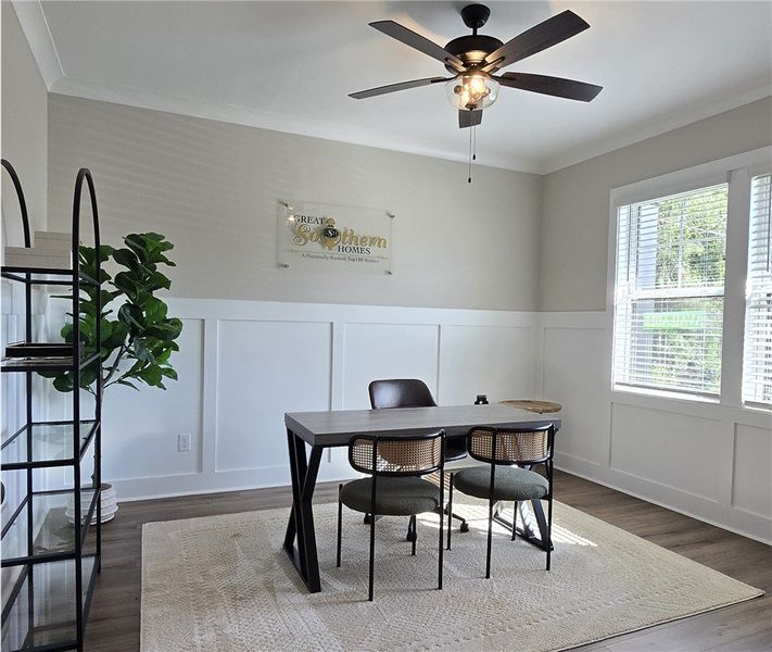 A well-lit study with a paneled accent wall and du A well-lit study with a paneled accent wall and du