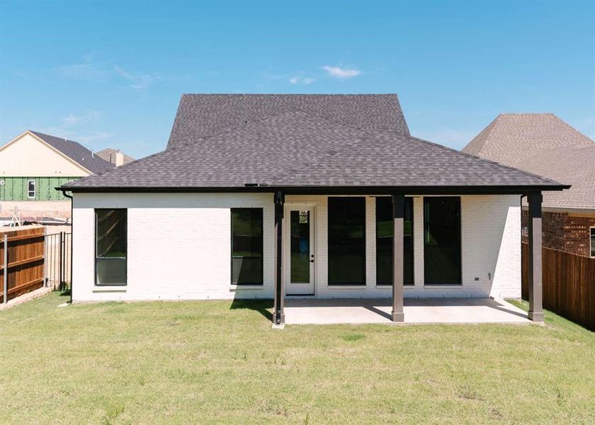 Rear view of property with a patio and a yard