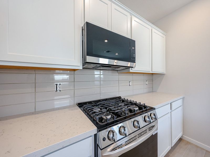 A kitchen with white cabinets.
